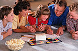 Family playing board games laying on the carpet